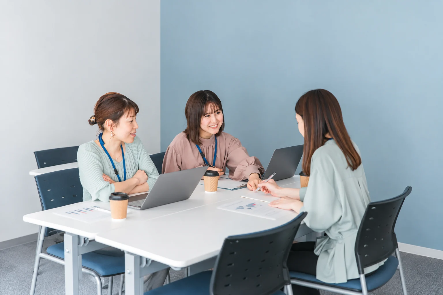 アクセスデータとWebサイトの設計資料を見ながら、改善策を相談するイメージ